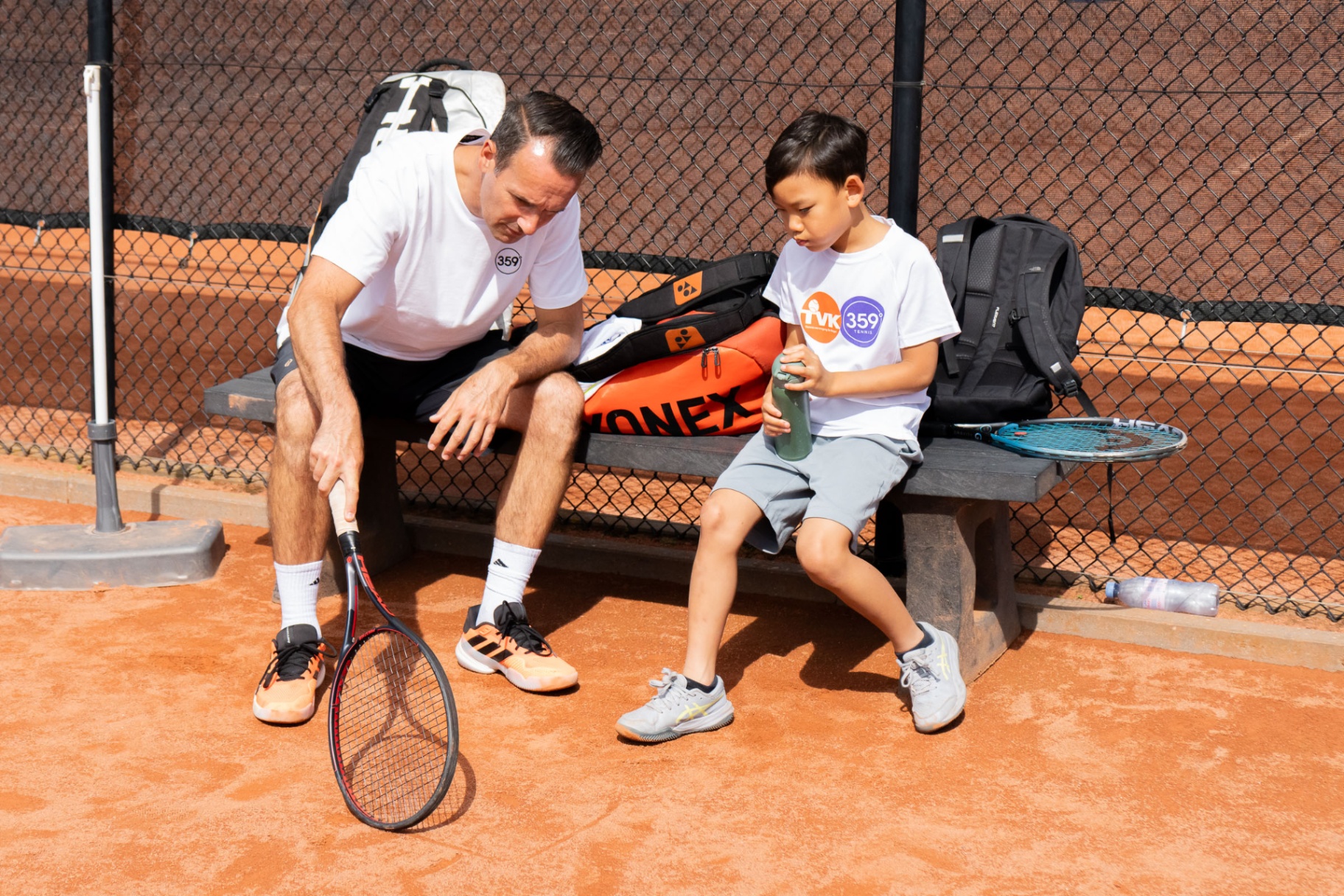 Coach en speler in overleg tijdens pauze — persoonlijke aandacht 359.tennis