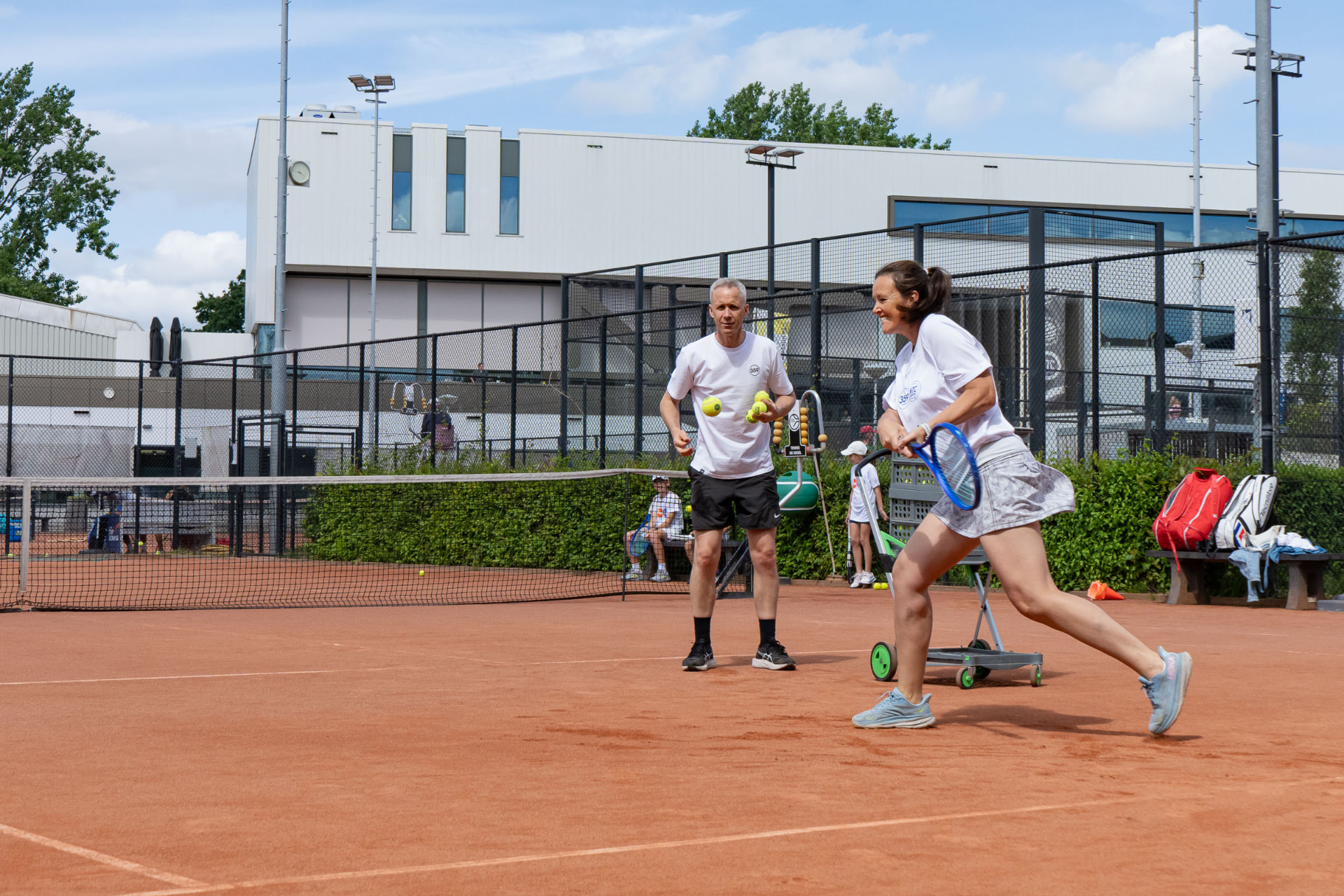 Two adults together on the outdoor court — 359.tennis, NTC Amstelveen
