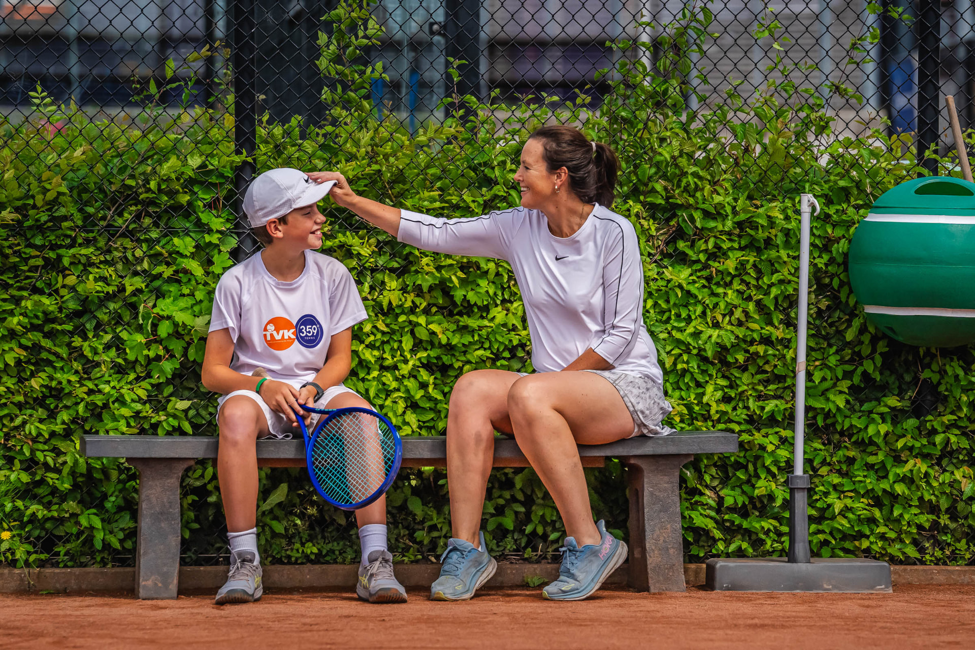Parent and child laughing together beside the court — 359.tennis, NTC Amstelveen