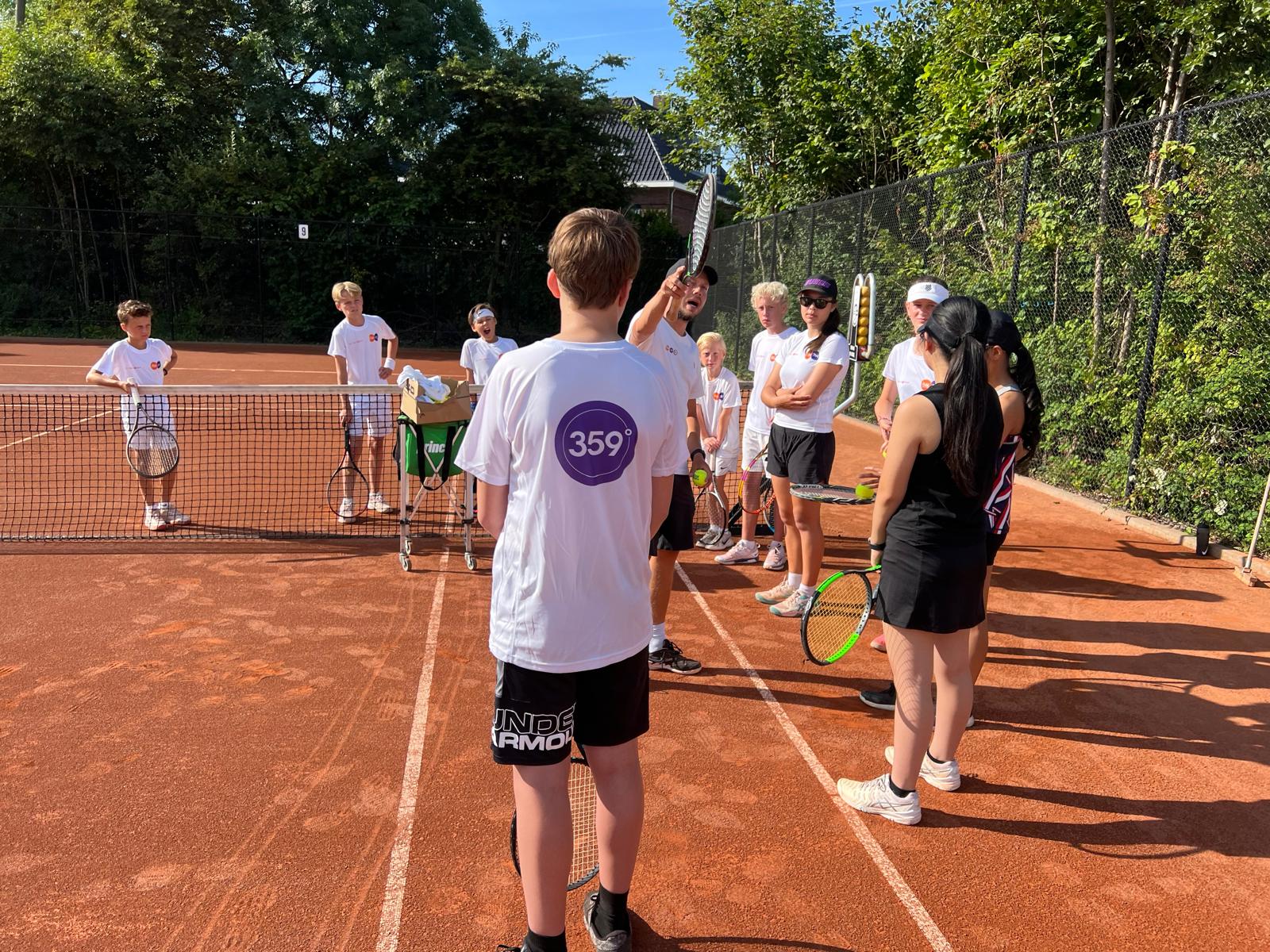 Listening together before the drill – 359 tennis camp Amstelveen