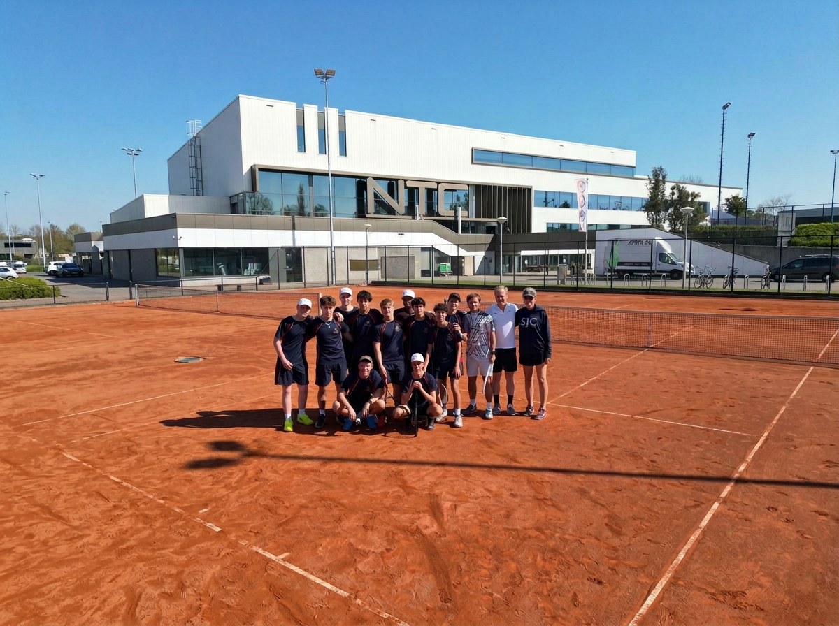 Tennisgroep van een Britse privéschool met 359-coaches op de gravelbaan voor het NTC-gebouw in Amstelveen