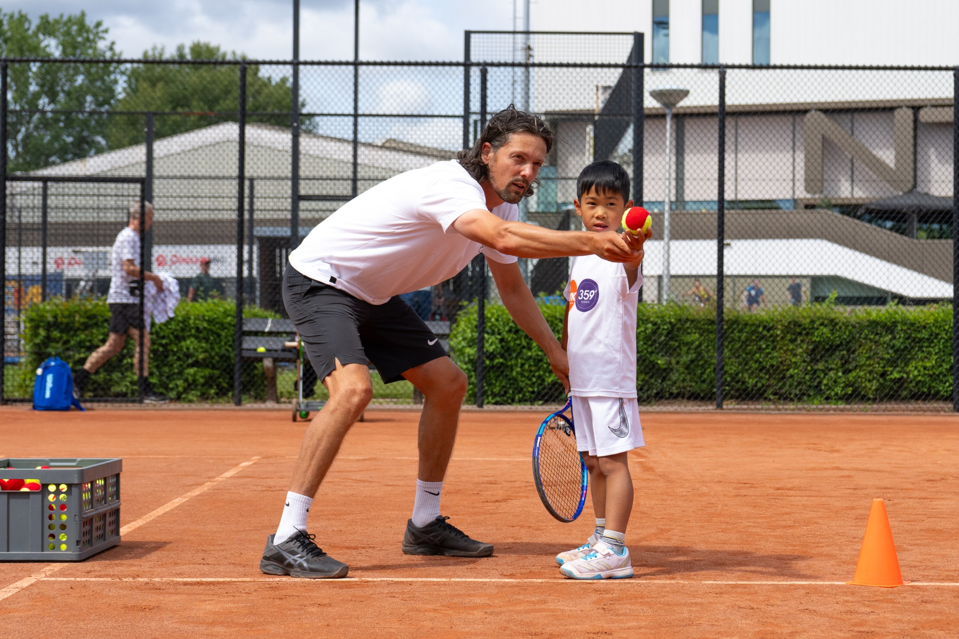 Coach voert ballen aan tijdens training — 359.tennis, NTC Amstelveen