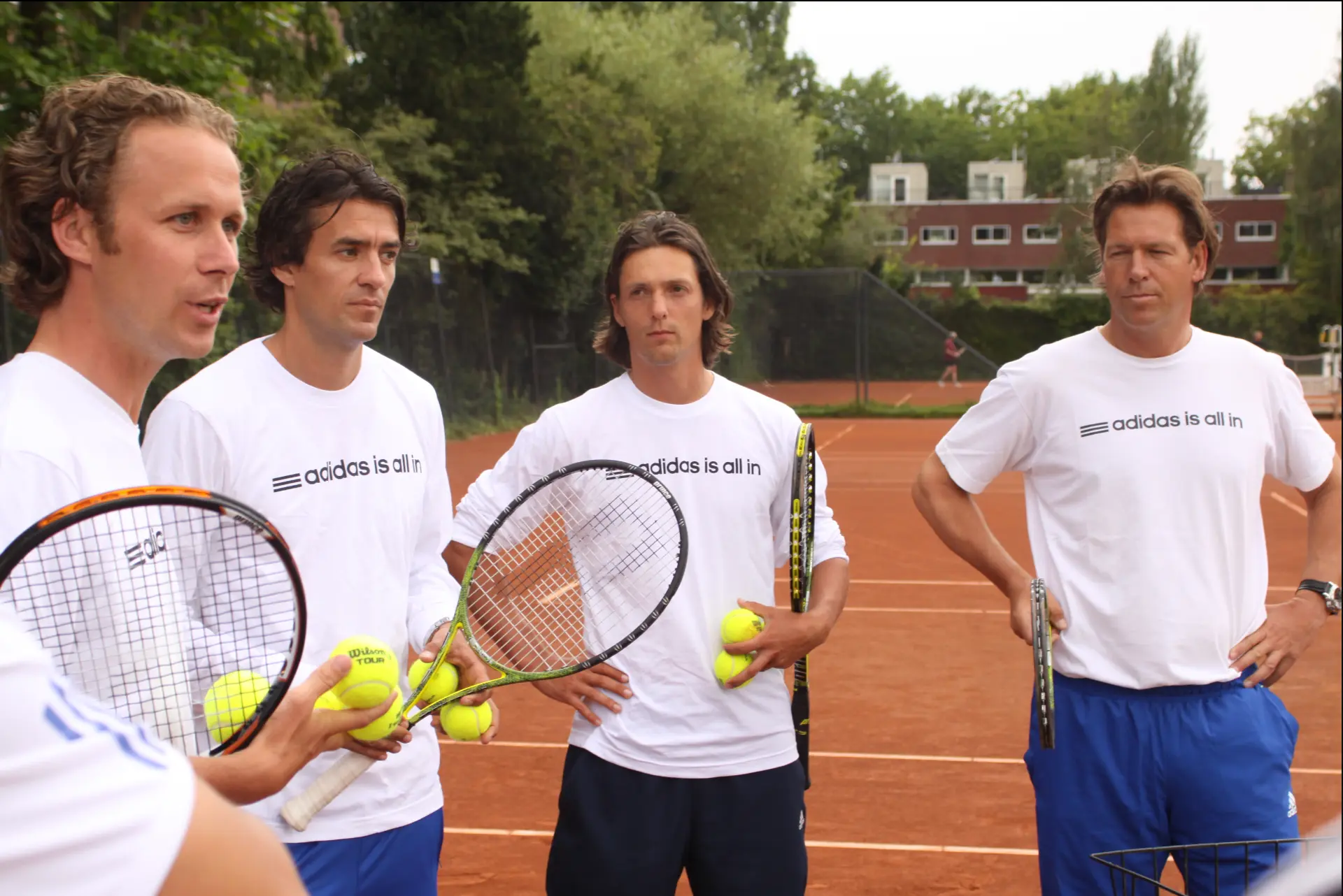 Coaches van Tennis Academy Amsterdam in adidas-shirts met rackets en ballen op de gravelbaan in Amsterdam, 2011.