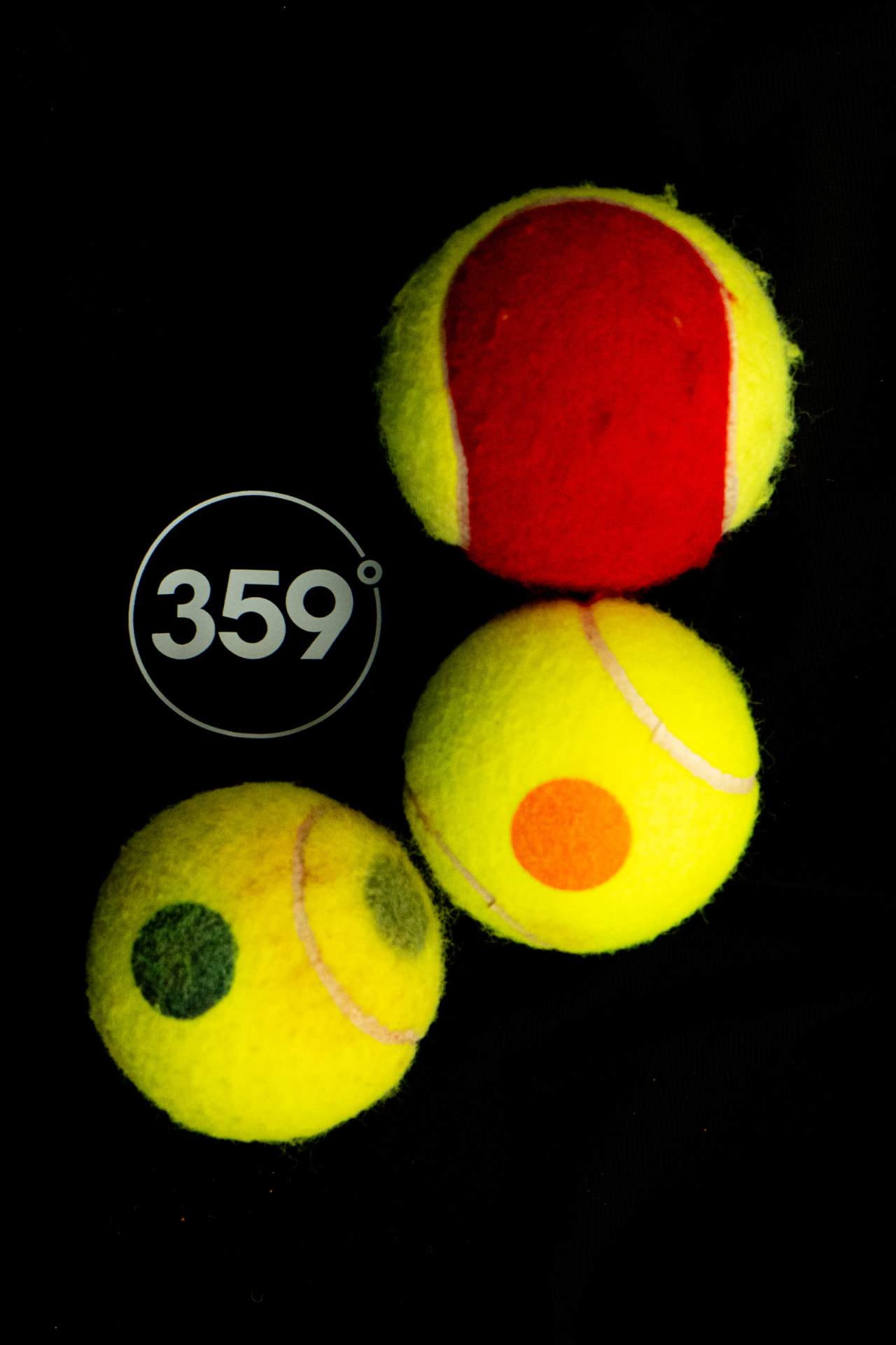 Rode, oranje-punt en groene KNLTB-Tenniskidsballen met 359-logo — de balkleur bepaalt het Tenniskids-programma