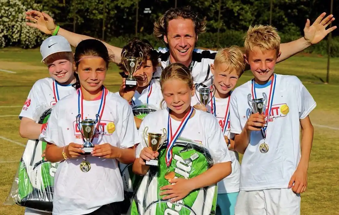Roland Laurense met een groep junioren na een toernooi met bekers en medailles